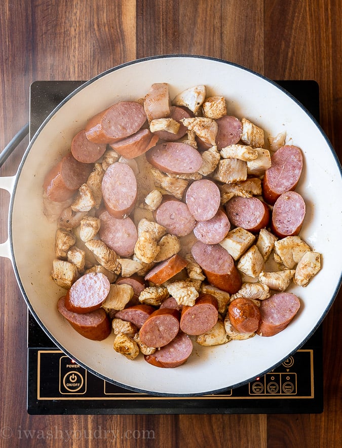 Sauté chicken and sausage in pan