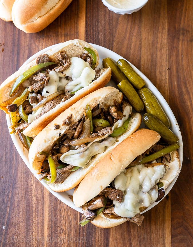 tray of sandwiches with beef and pickles on the side