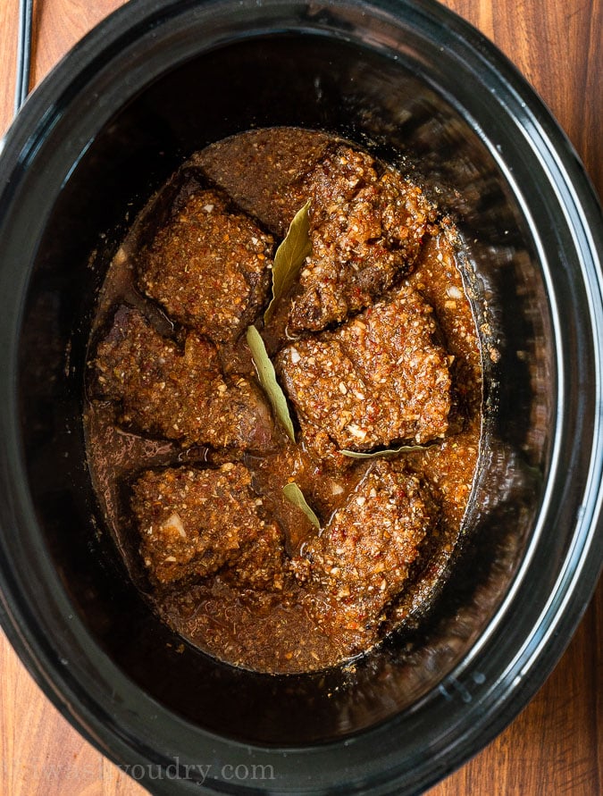 chuck roast in slow cooker with sauce on top