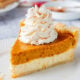 Slice of Pumpkin cheesecake pie on white plate.