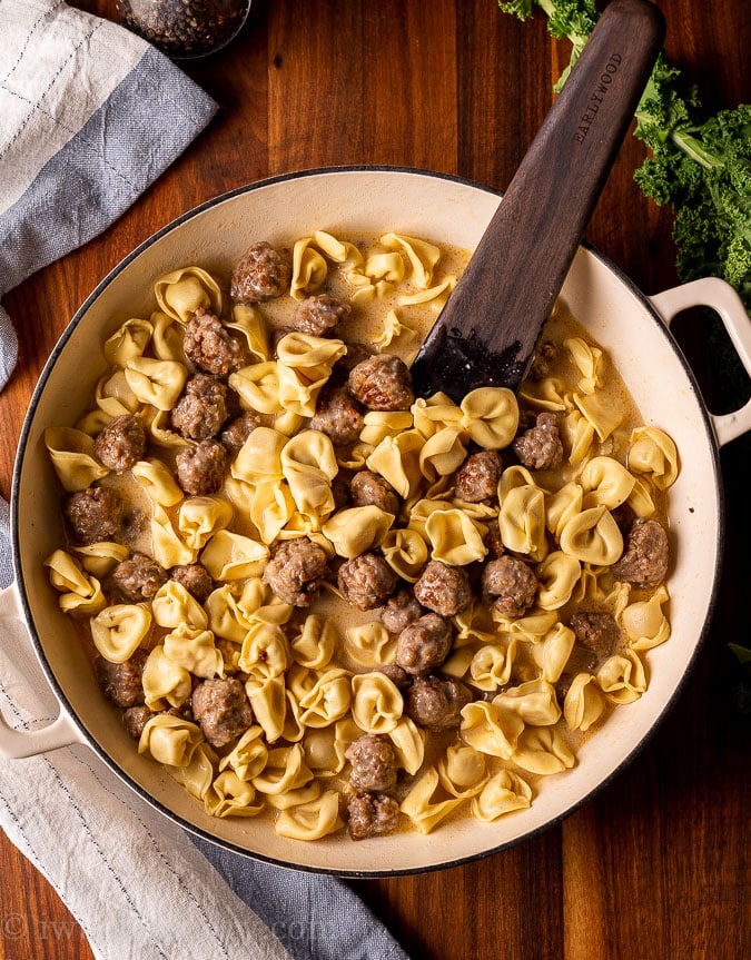 meatballs and tortellini in pan with wooden spoon