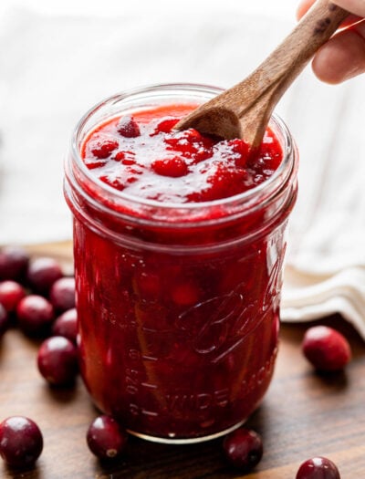 Sweet cranberry sauce in mason jar with spoon