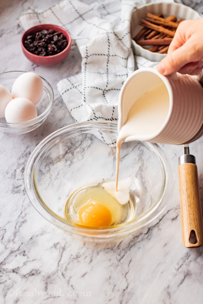 pouring cream into glass bowl with egg. 