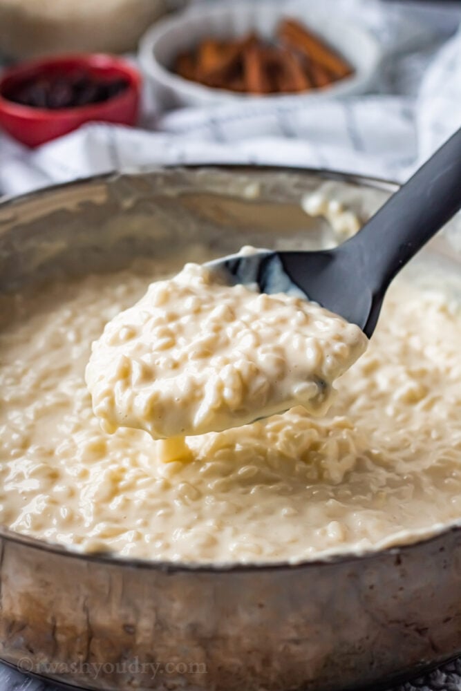 Thickend homemade rice pudding in metal pan with spoon. 