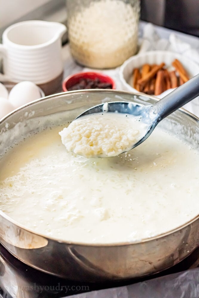 milk and rice in metal pan with spoon. 