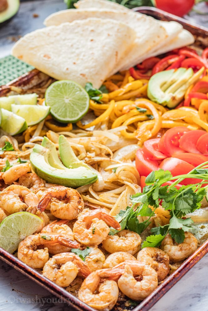 Baked sheet pan shrimp fajitas in a metal pan.