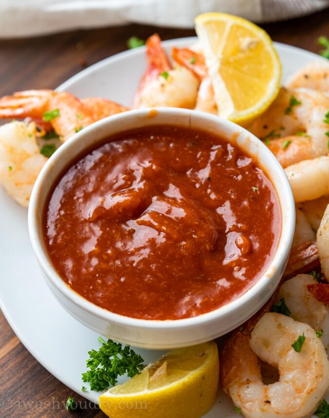white bowl with cocktail sauce and shrimp