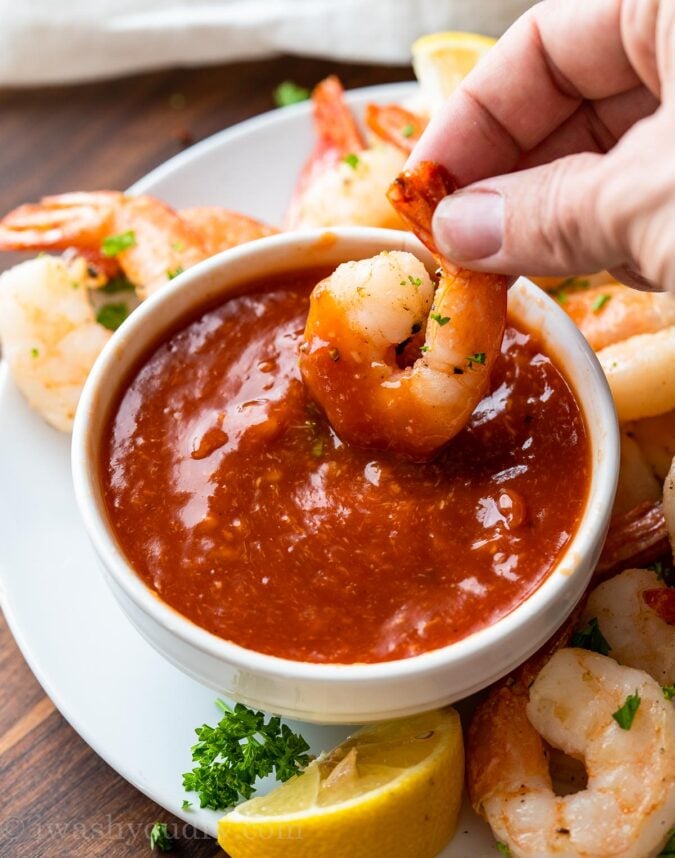 dipping shrimp in cocktail sauce