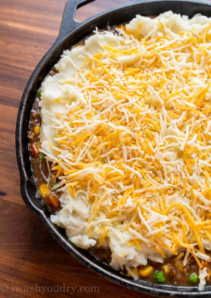 shredded cheese with mashed potatoes in pan