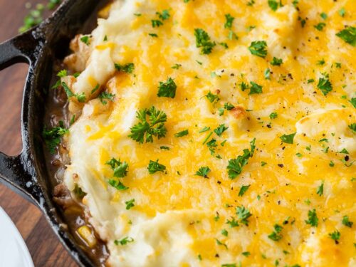 cast iron skillet with cottage pie and cheese