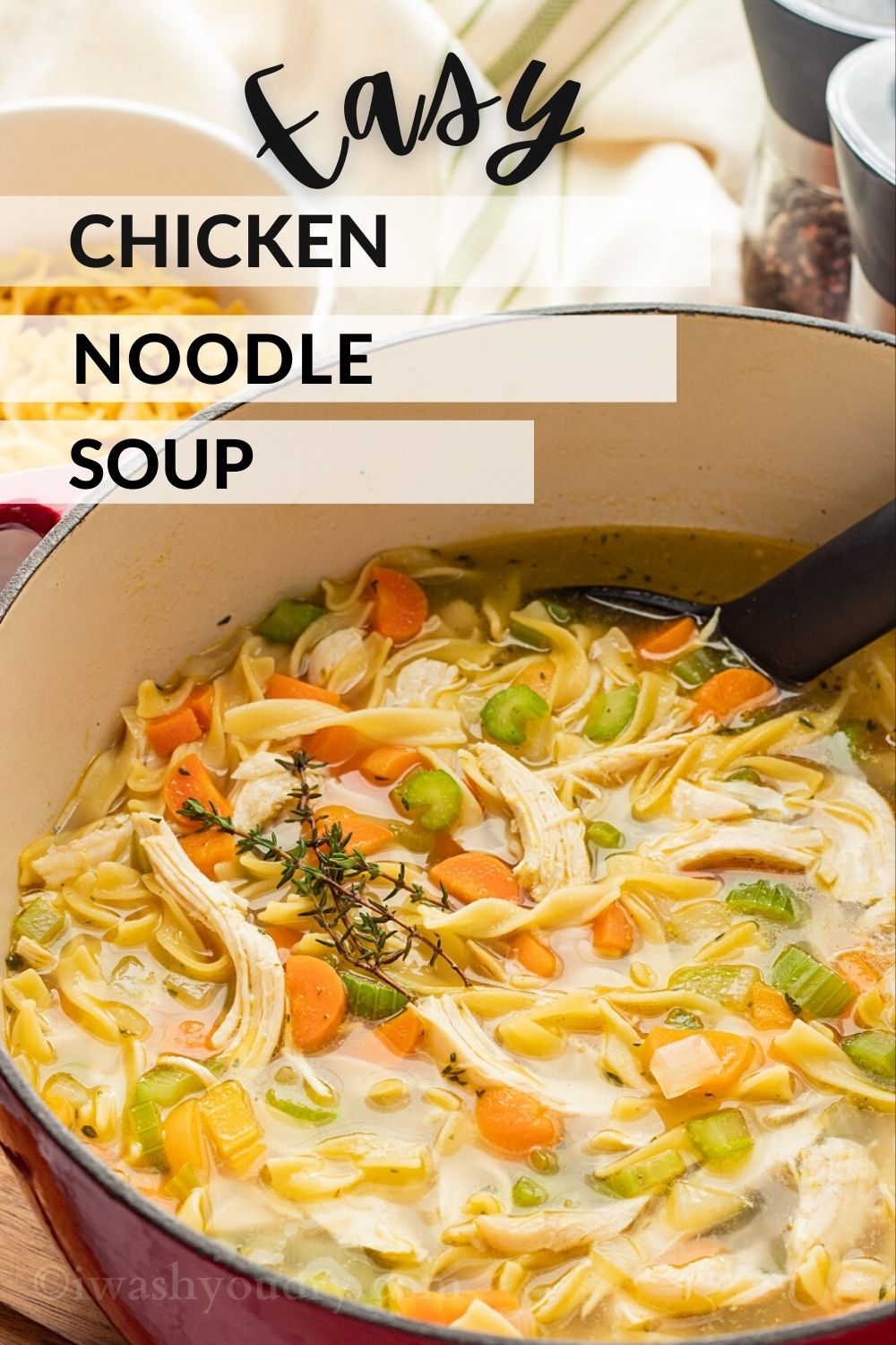 Red pot of cooked chicken noodle soup with text overlay of title of recipe. 