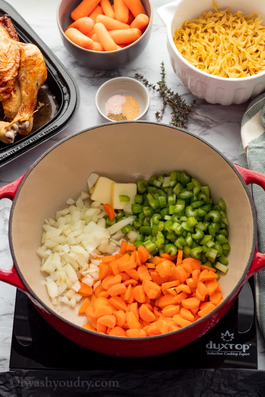 chopped onion, celery, and carrots in red pot on cooktop. 