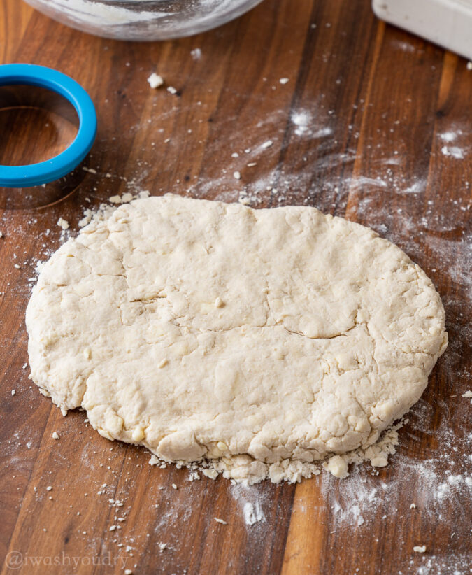 biscuit dough on floured surface with circle cutter