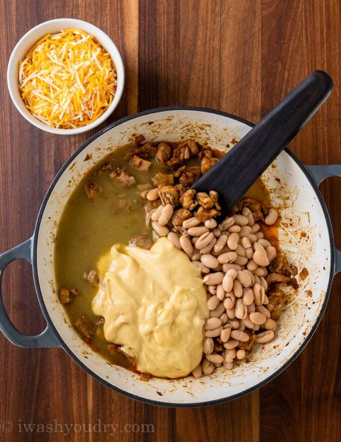 skillet with chicken, sauce and beans and cheese on the side