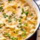 Skillet with cheesy chicken enchiladas and green onions