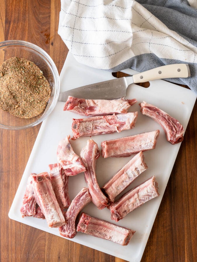 Ribs and seasoning on white cutting board