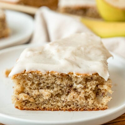 slice of banana cake with frosting on plate.
