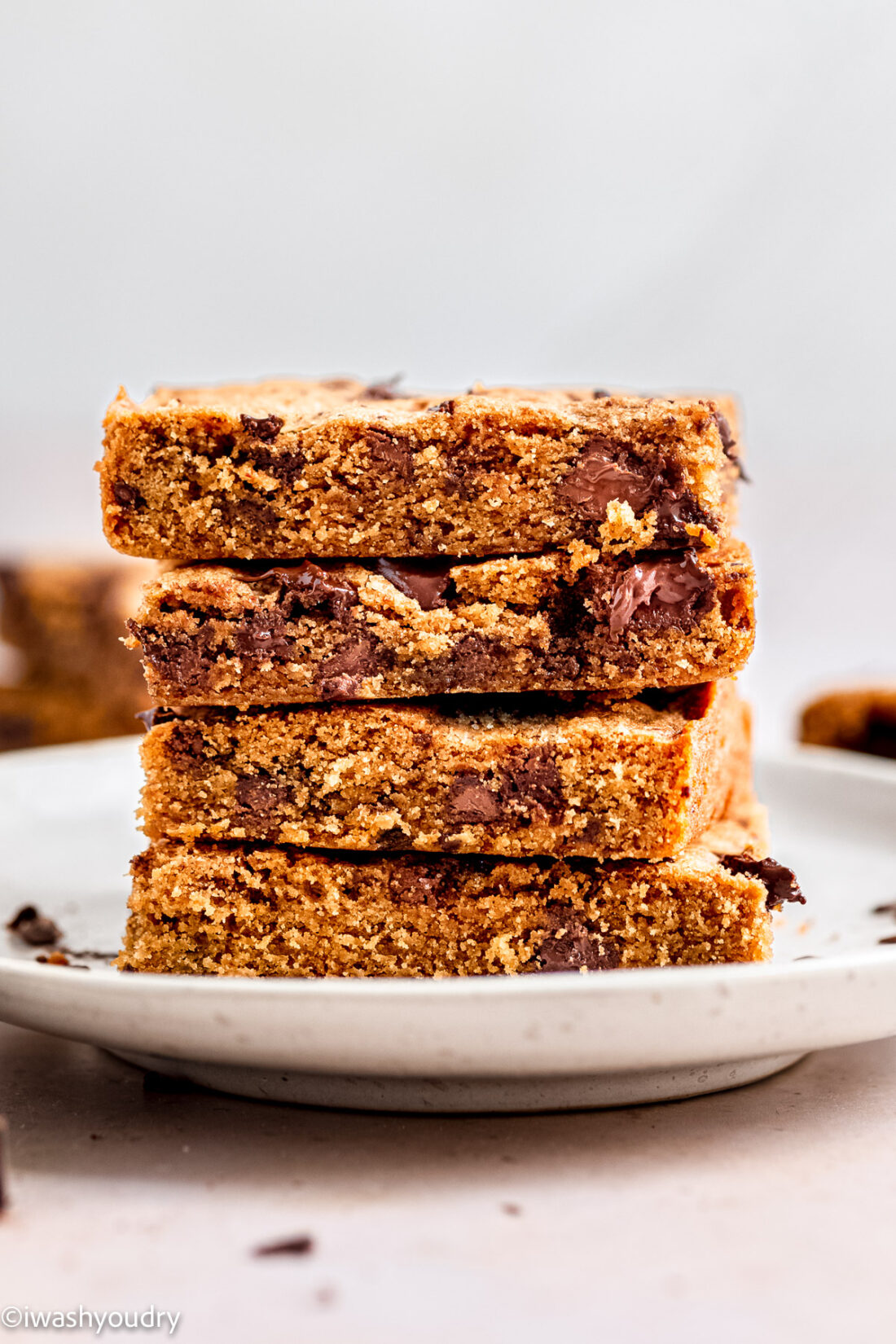 Stack of 4 baked blondie slices on white plate. 