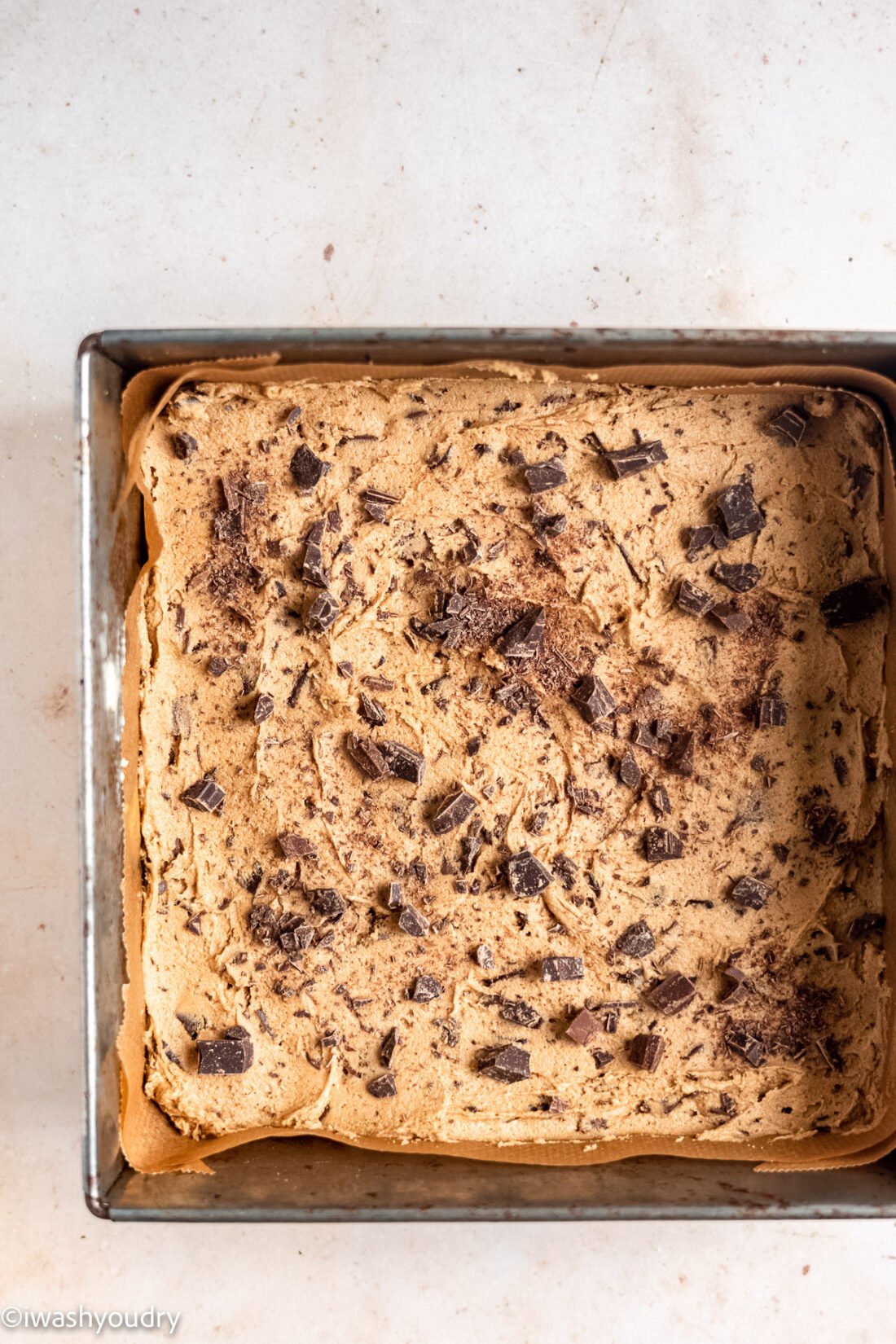 Raw chocolate chip blondie batter in a square metal skillet. 