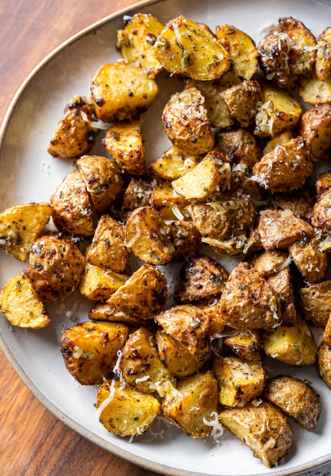 golden brown potatoes with parmesan cheese on white plate