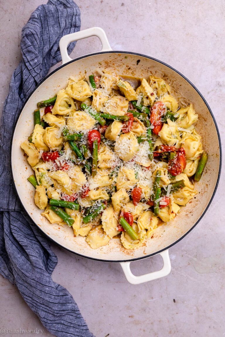 cheesy tortellini in pan with asparagus and tomatoes