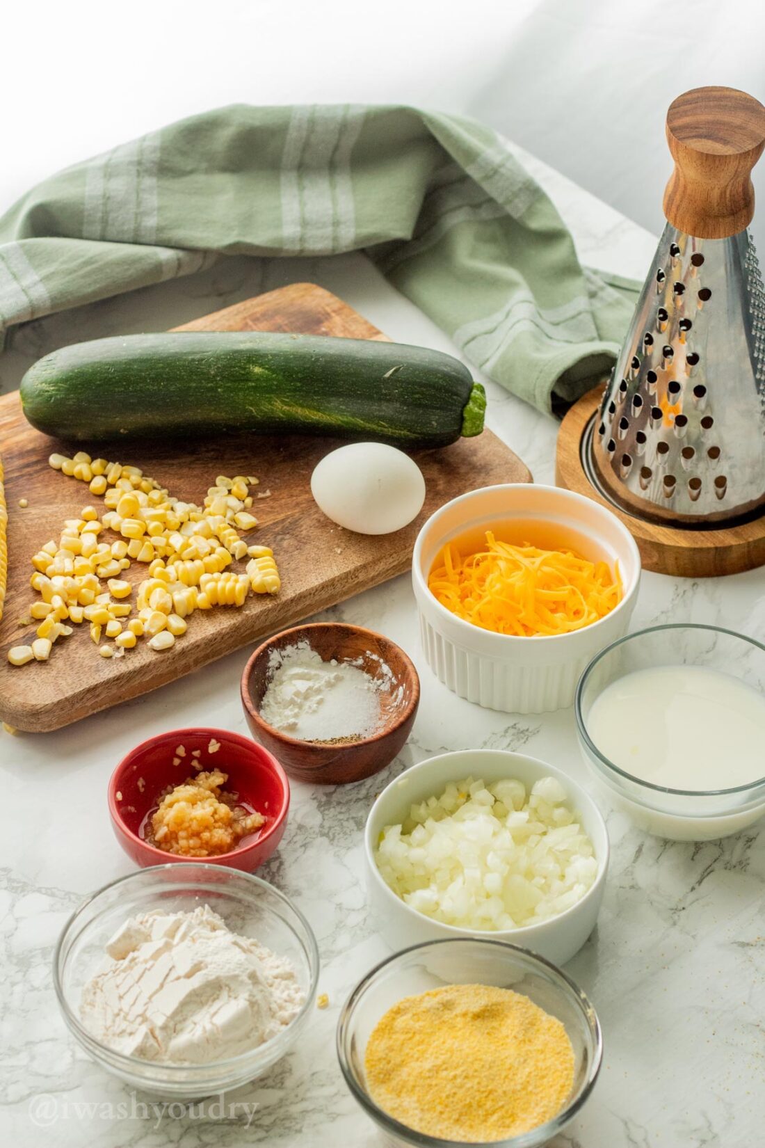 Ingredients for Zucchini Corn Fritters on marble. 