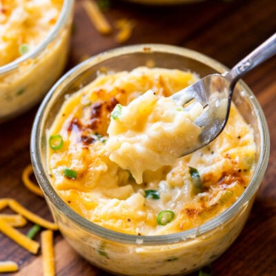 fork full of potatoes with cheese.