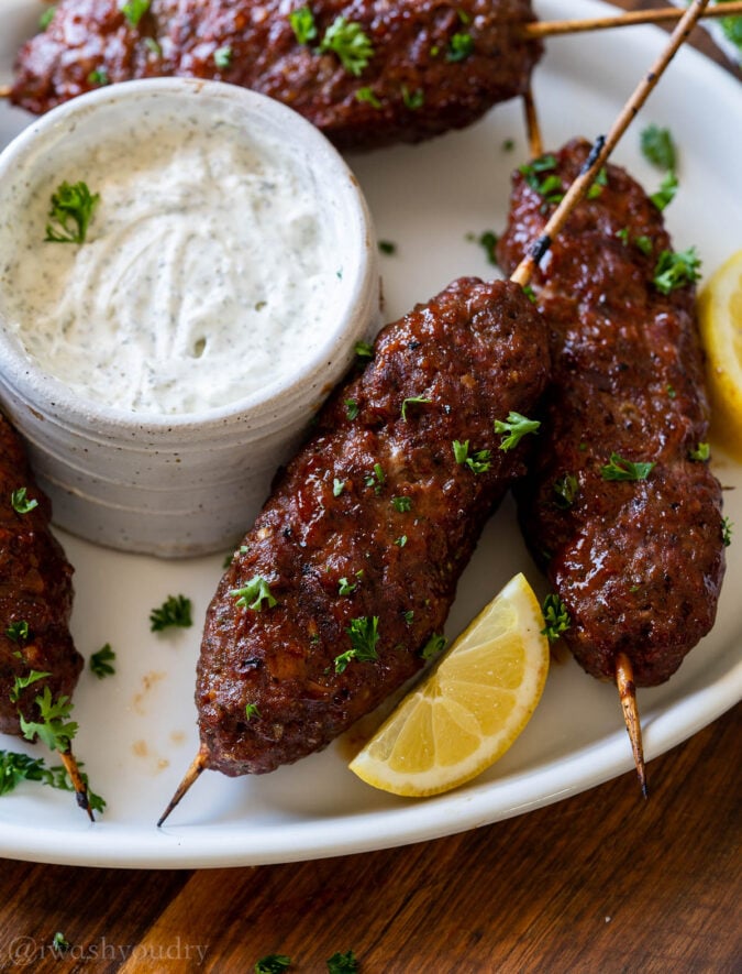 Grilled meatloaf on white plate with creamy sauce.