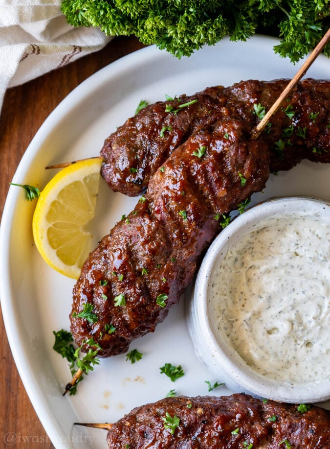 plate of meatloaf skewers with cream sauce and lemon. 