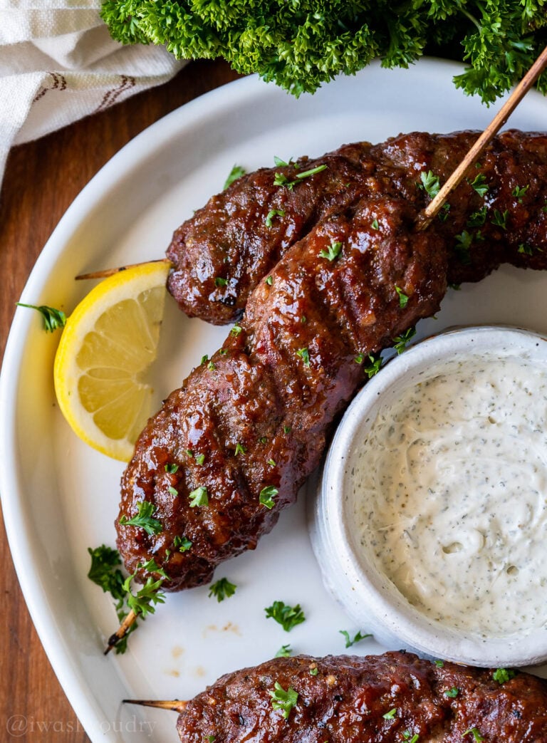 plate of meatloaf skewers with cream sauce and lemon.