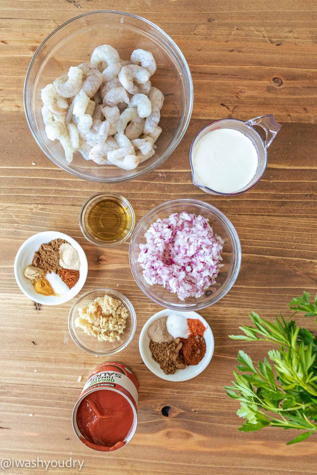 Ingredients for creamy shrimp tikka masala on a wooden cutting board. 