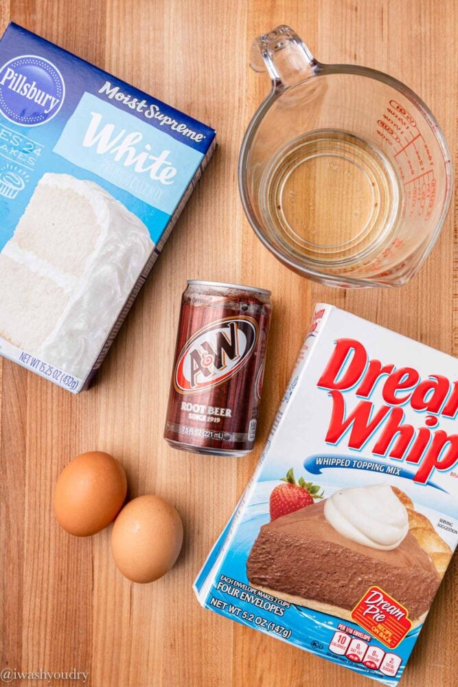 Ingredients for cake placed on wood surface with root beer.