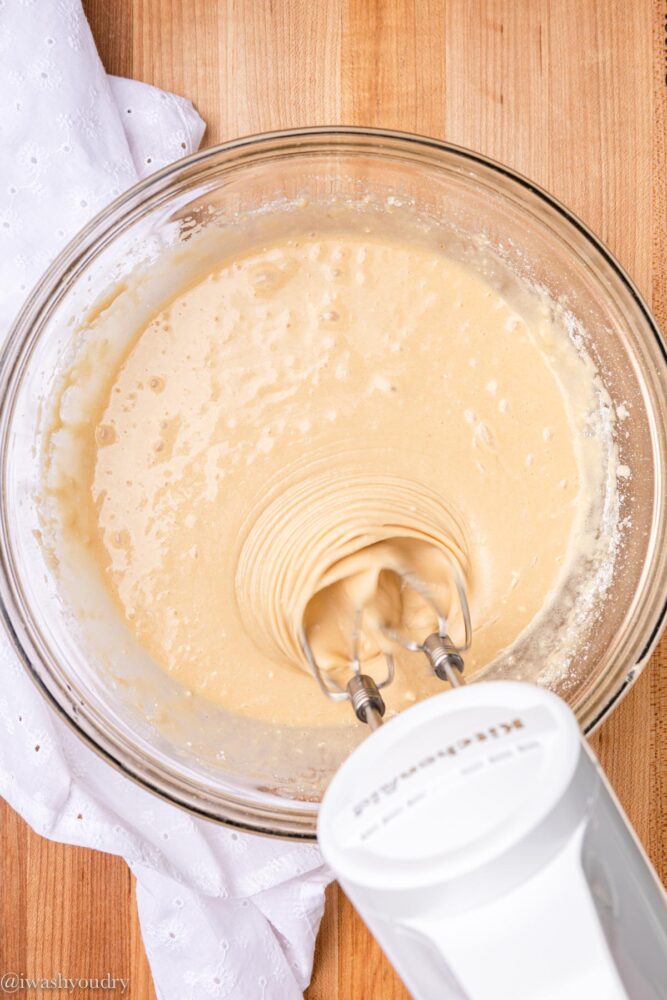 mixing cake batter in bowl with mixer.