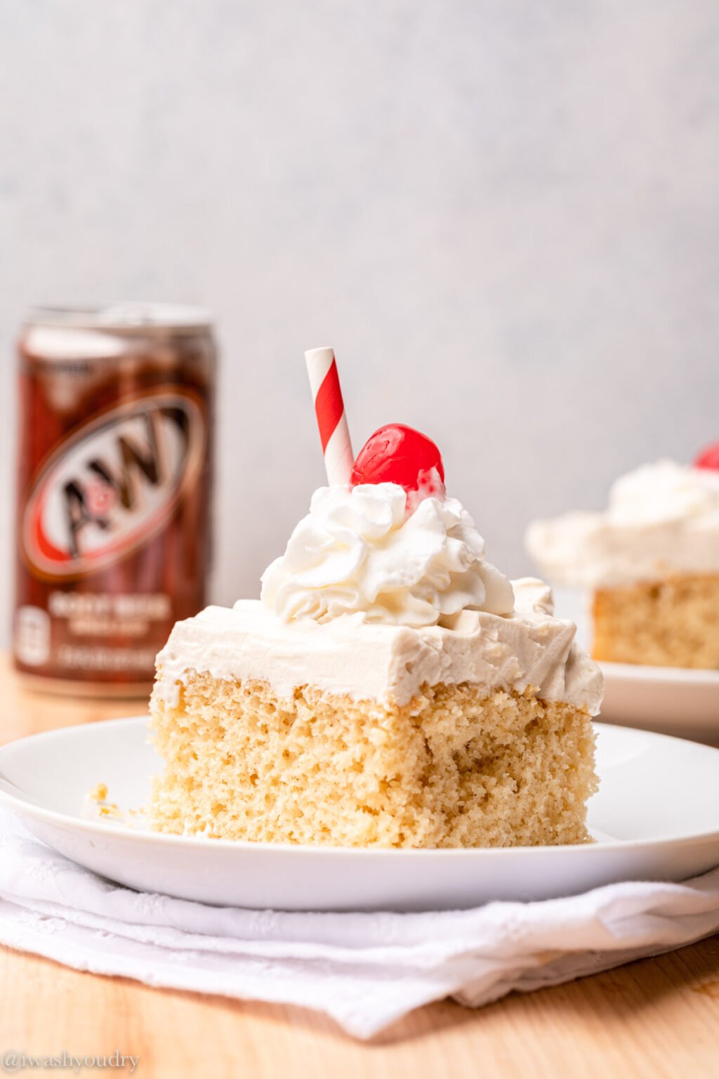 slice of cake on white plate with cherry on top.