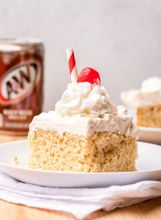 slice of cake on white plate with cherry on top.