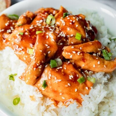 plate of chicken thighs with honey garlic sauce and sesame seeds.