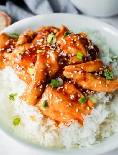 plate of chicken thighs with honey garlic sauce and sesame seeds.