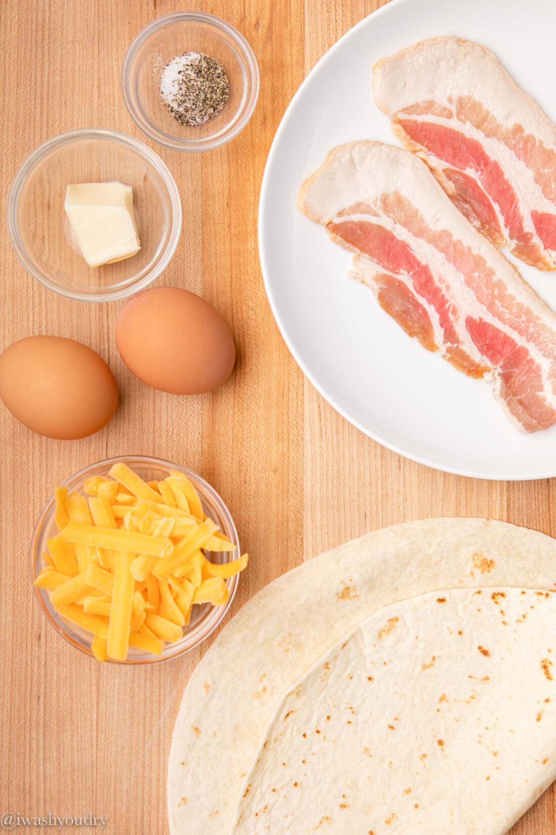 Ingredients for easy breakfast quesadillas on a wooden cutting board. 