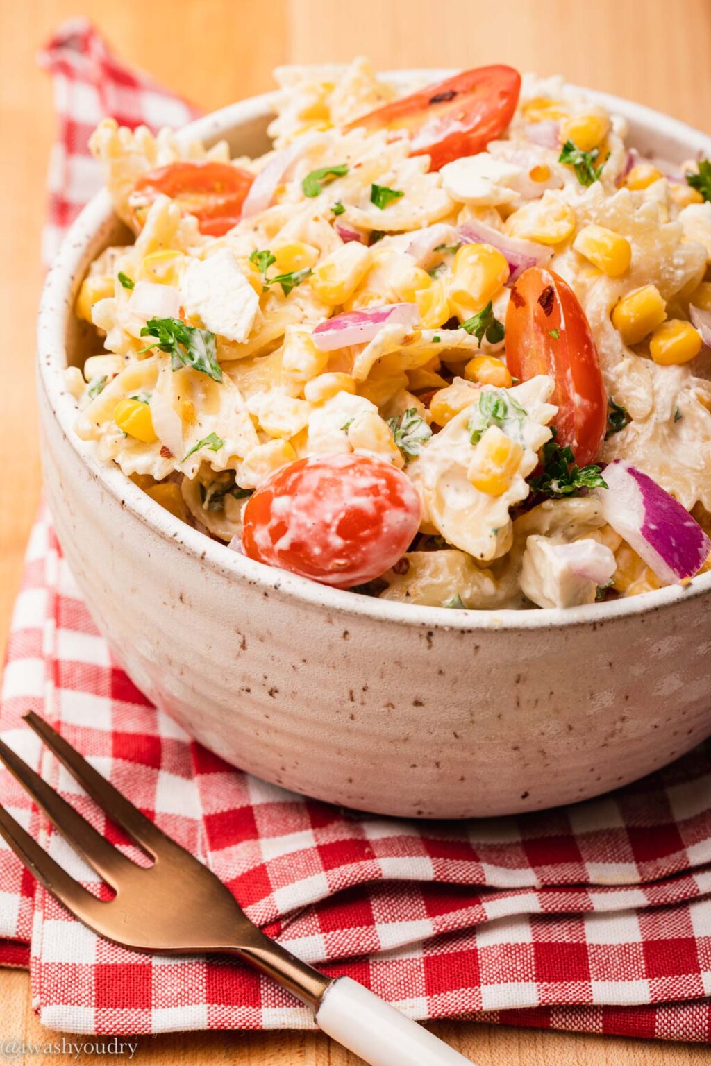 bowl of pasta salad with corn on red napkin