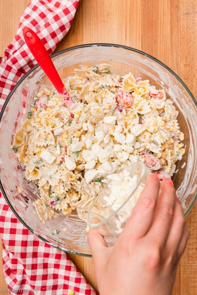 add feta cheese to a bowl of pasta salad