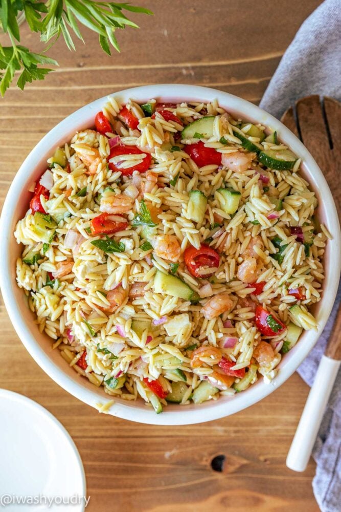 shrimp pasta salad with orzo and cucumbers in white bowl