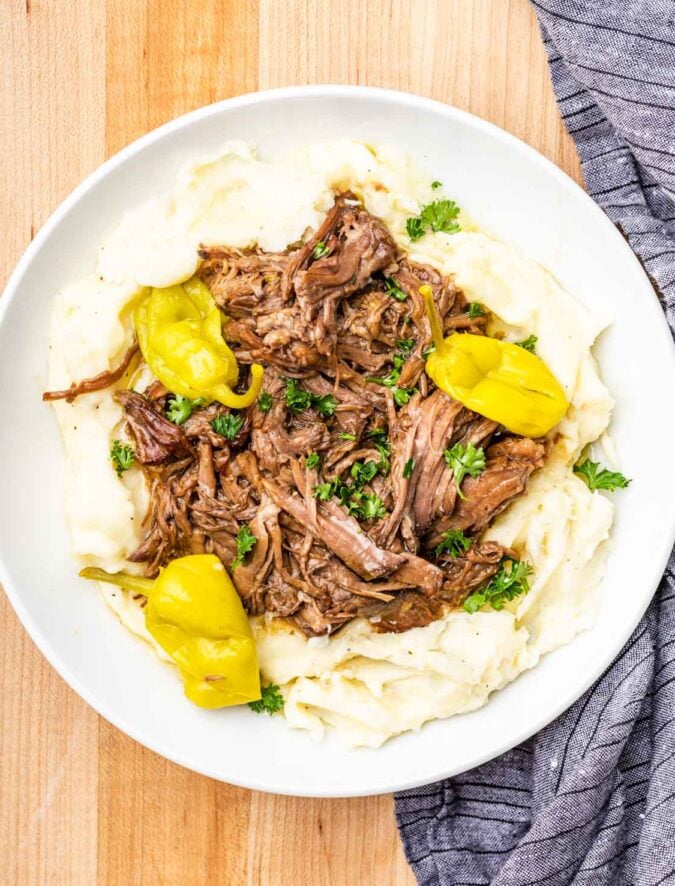 white plate with mashed potatoes and shredded beef