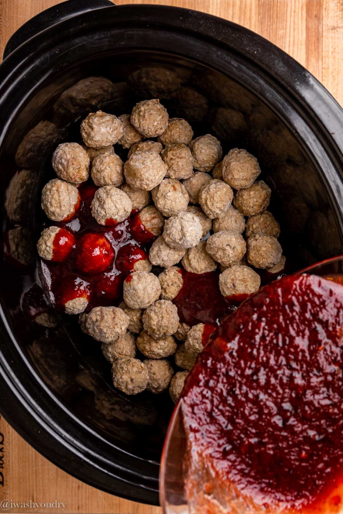 Pouring sauce over frozen meatballs in slow cooker. 