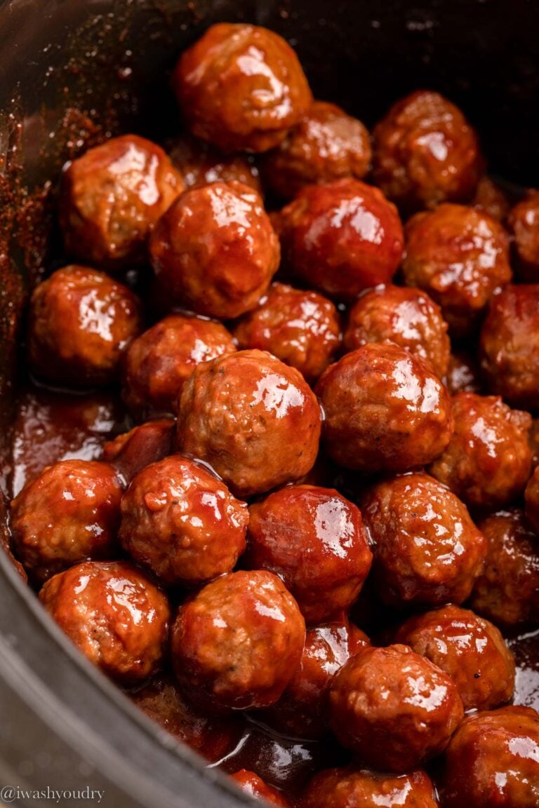 Cooked 3 ingredient cocktail meatballs in black slow cooker.