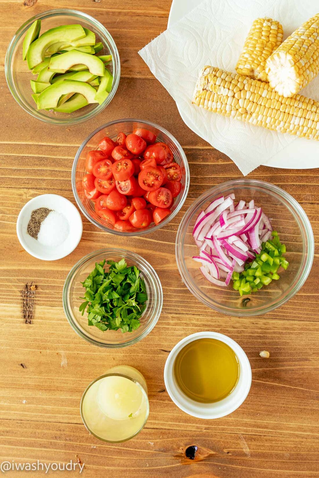 Ingredients for avocado corn salad on wooden surface. 