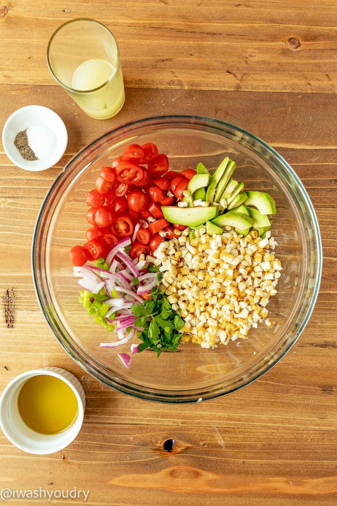 Bowl of ingredients with corn and avocado. 