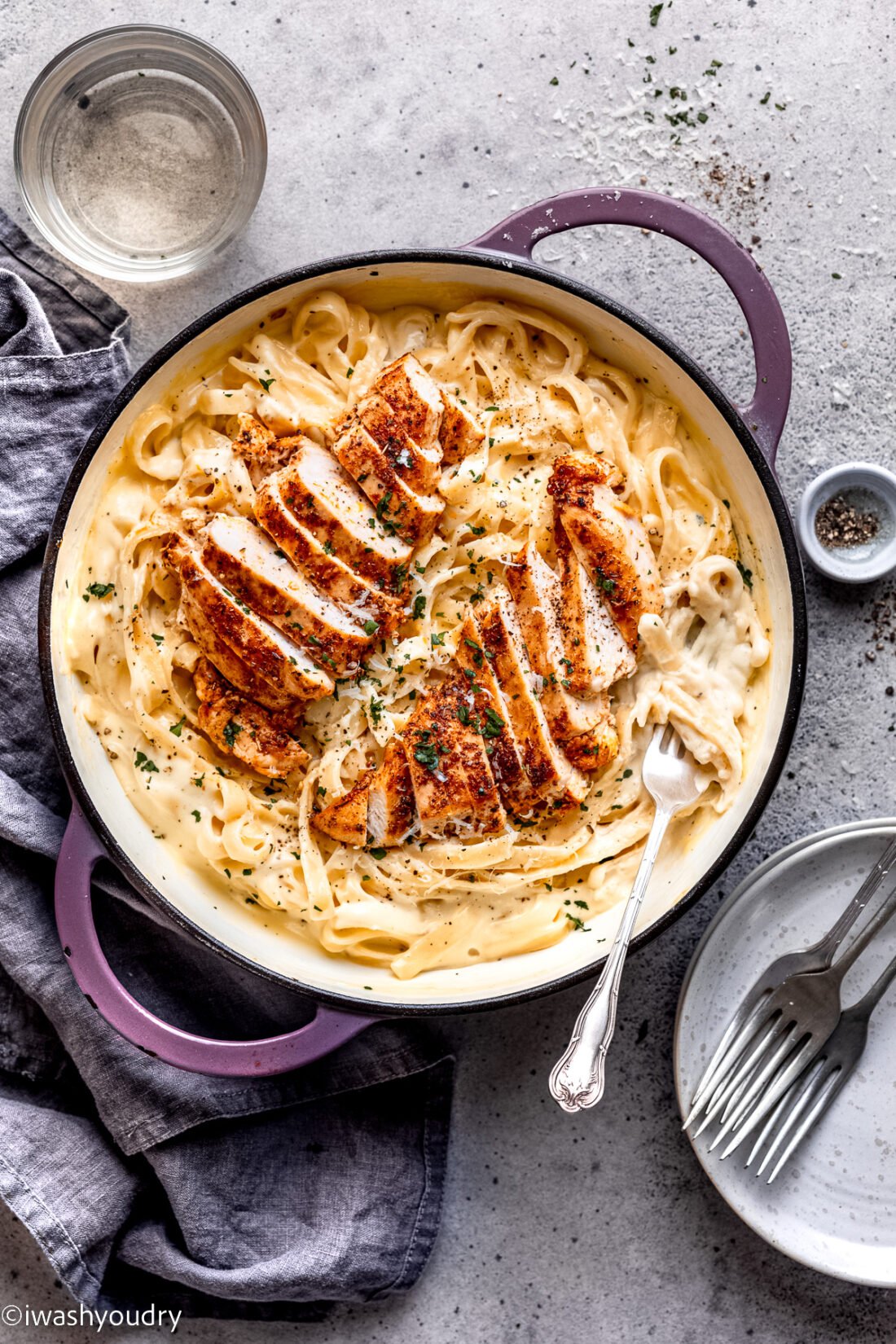 Cooked Chicken in pan of alfredo with noodles. 