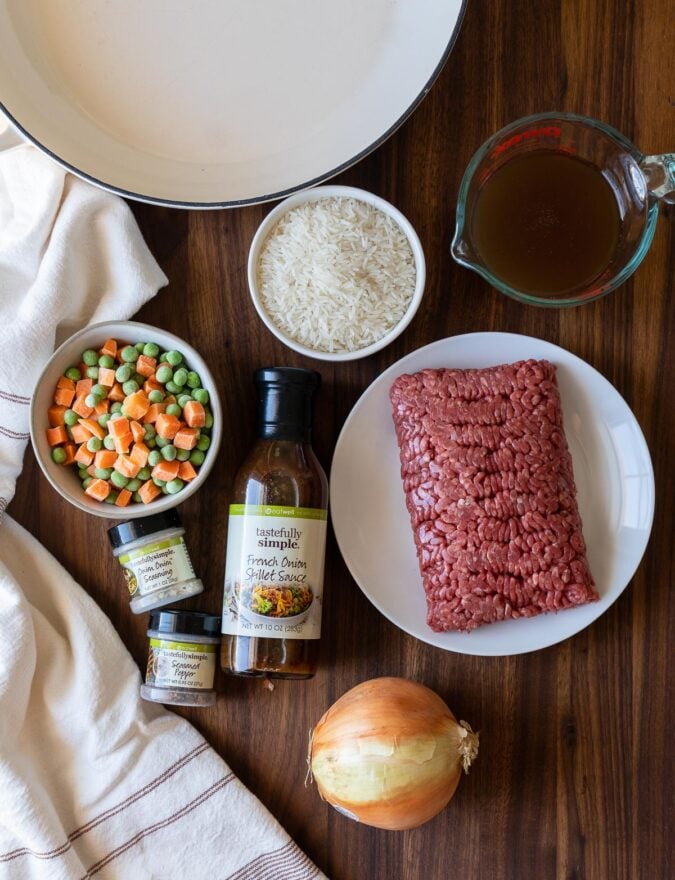 ingredients on wooden table with ground beef and onion