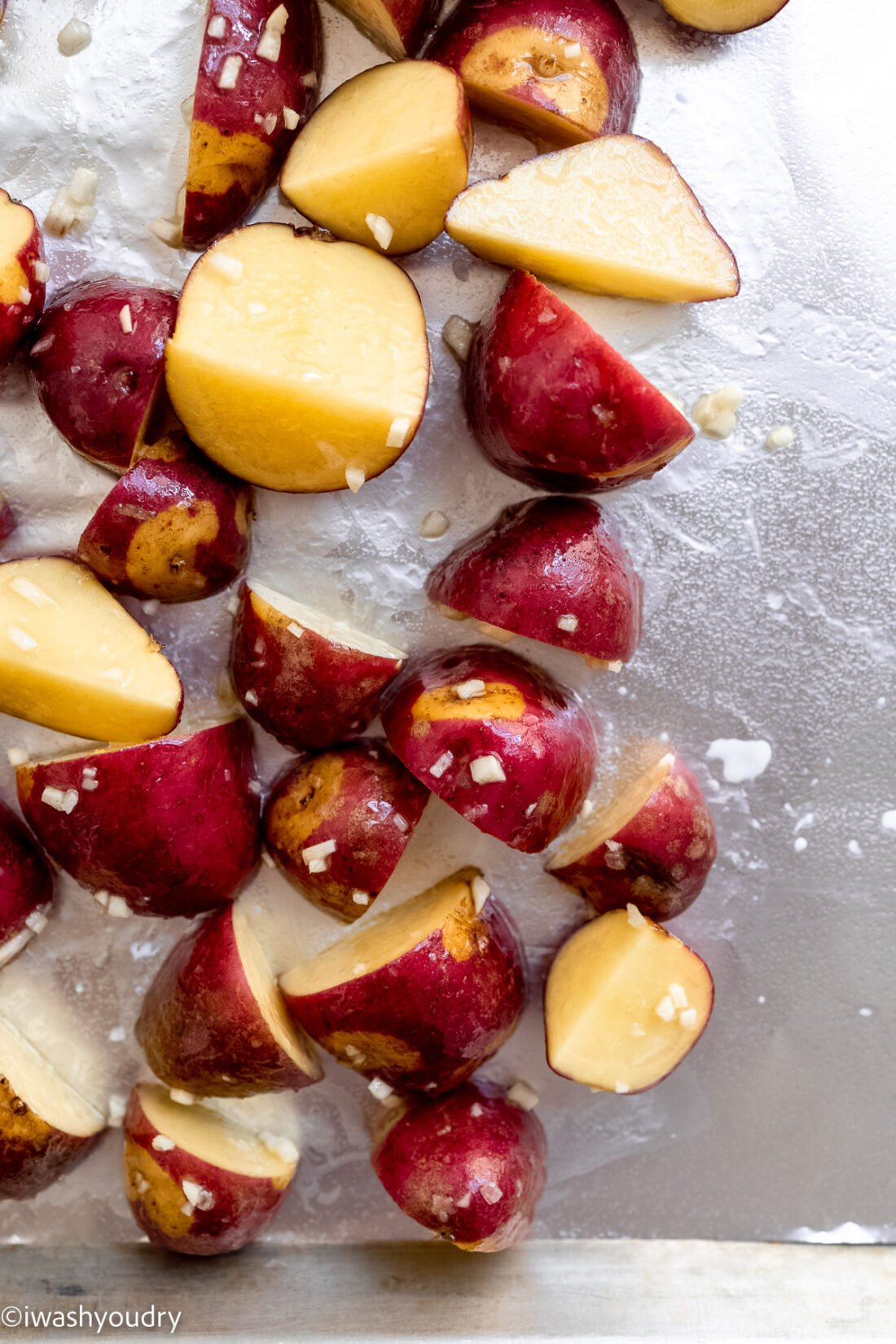 Raw red potatoes on a baking sheet. 