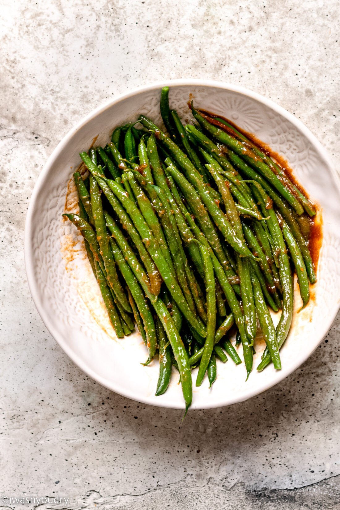 seasoned green beans with brown sugar in white bowl.